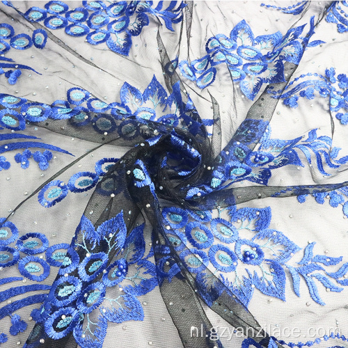 Marineblauwe geborduurde kantstof met bloemenprint